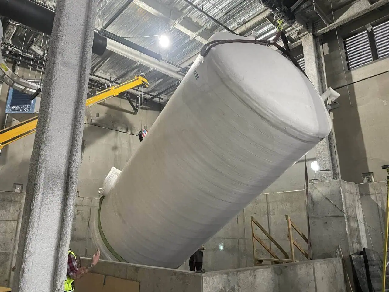 Heavy rigging of a large fiberglass waste tank by MEI Industrial Solutions for industrial storage.
