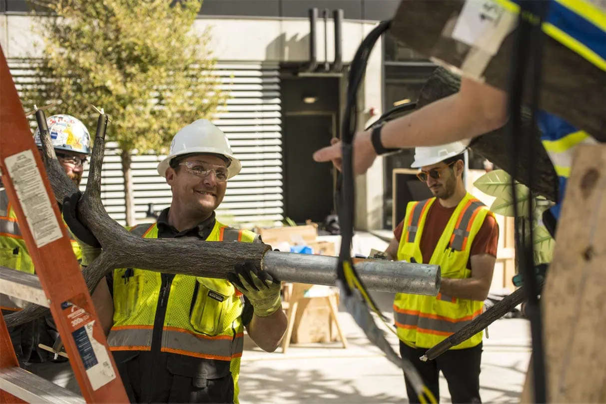 MEI Industrial Solutions field crew smiling while handling branch components during The Tree of Ténéré installation