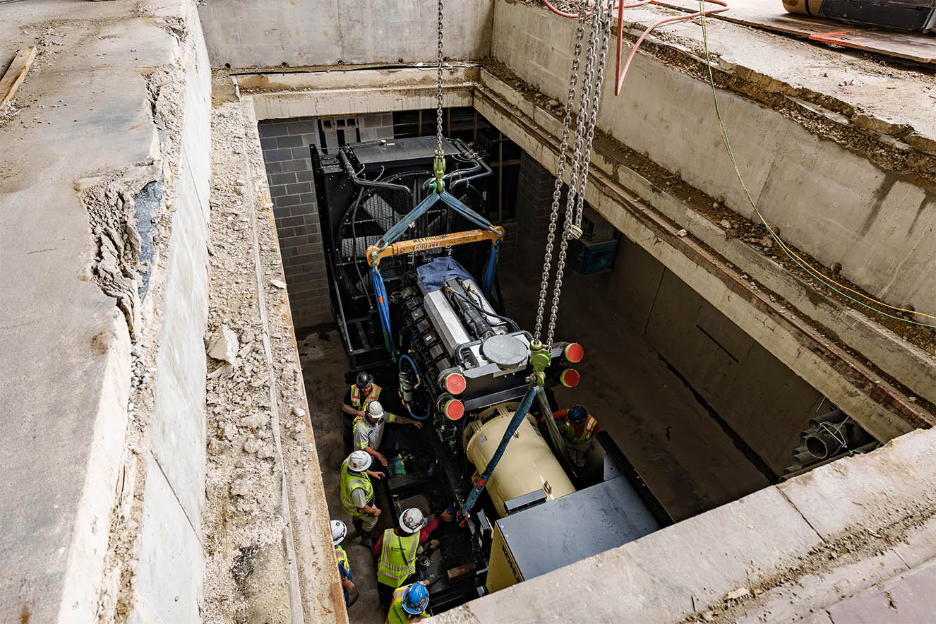MEI Industrial Solutions' heavy machinery moving services lower industrial equipment into a pit.