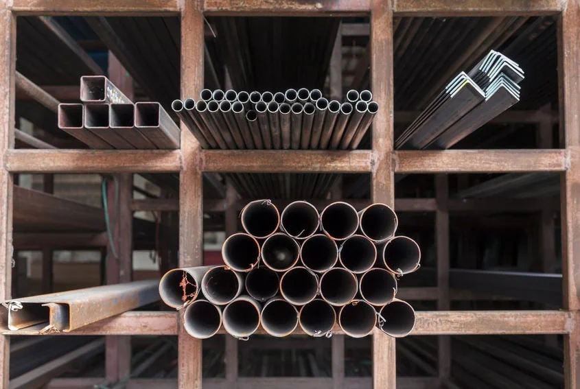 Stacked metal pipes in storage rack at MEI Industrial Solutions.